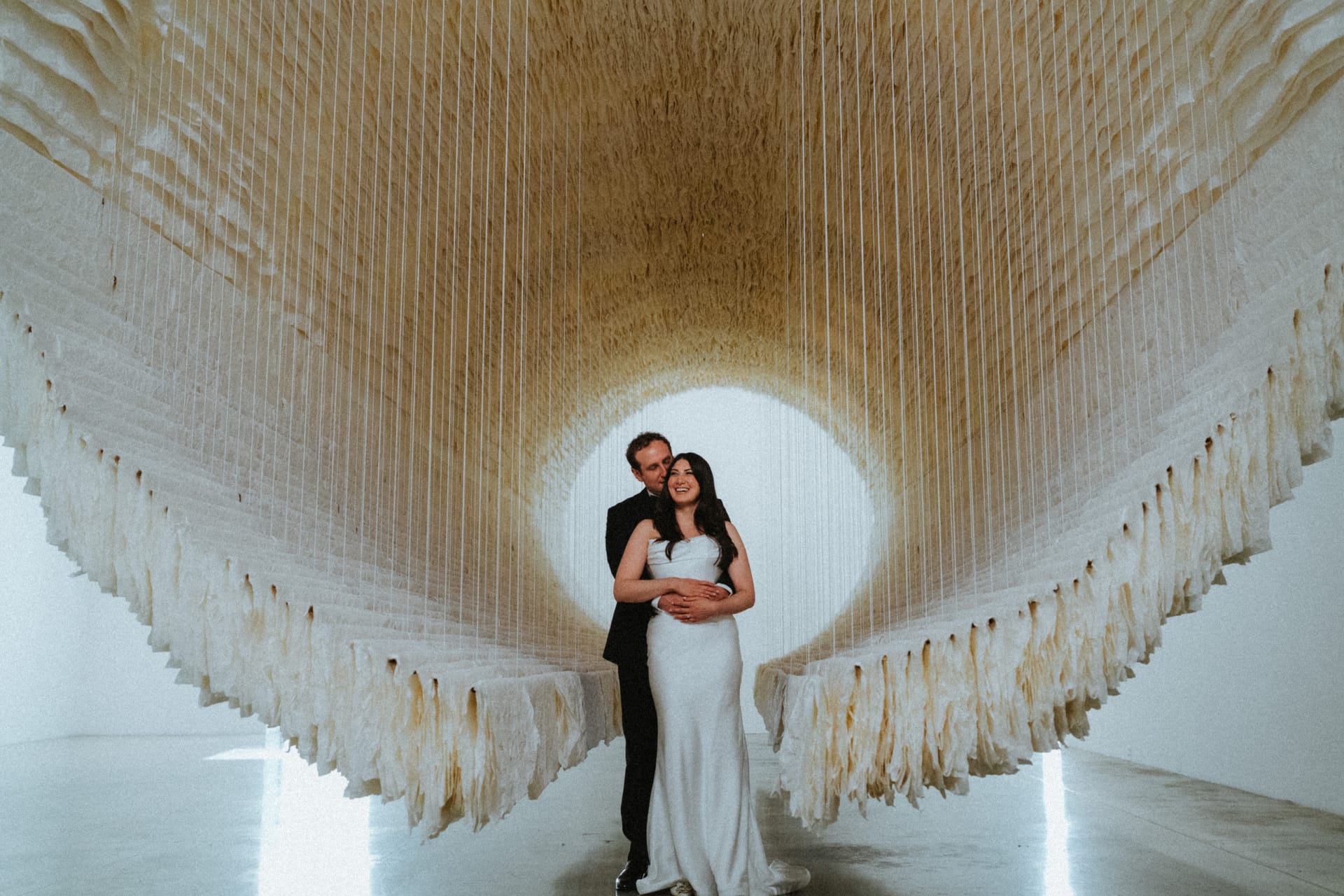 Jewish wedding ceremony under chuppah with florals and greenery