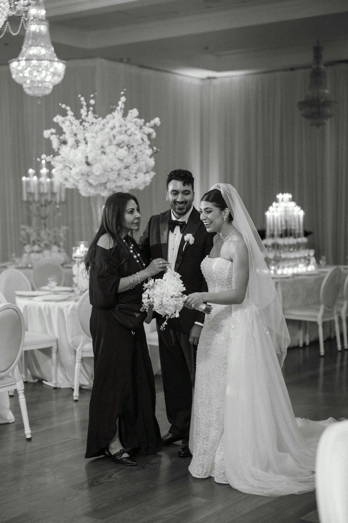 Mariane sharing a joyful moment with a bride and groom at their reception